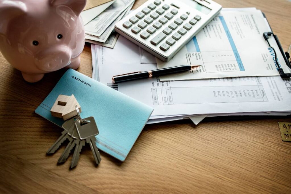 Keys, piggy bank, and financial documents symbolising property budgeting and investment planning.