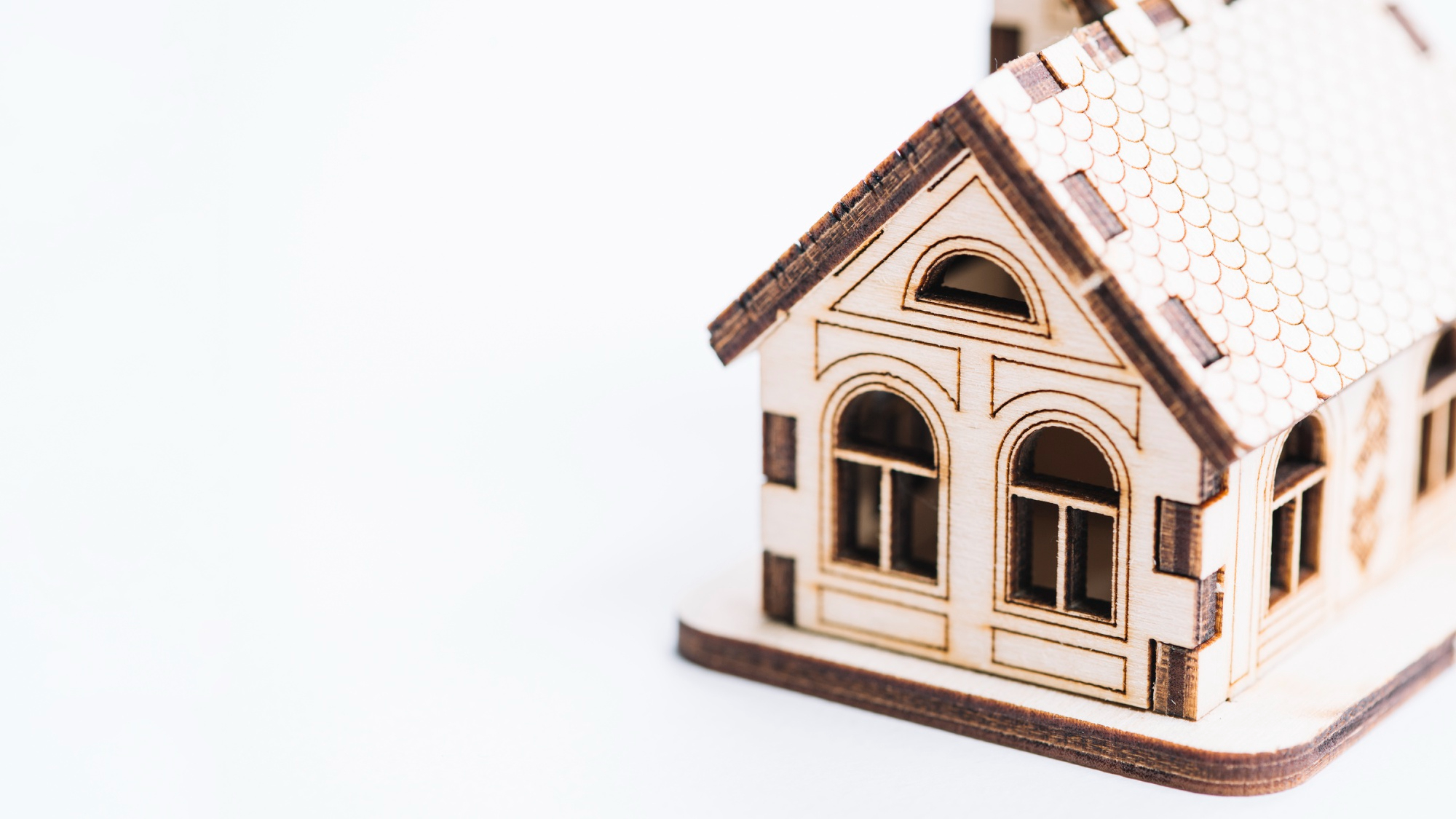 Wooden model house symbolising a rental property investment and landlord responsibilities.