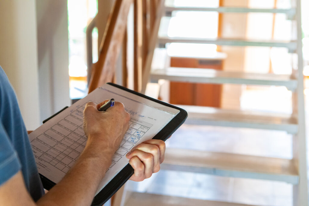 Property inspector completing an inspection checklist inside a residential home.