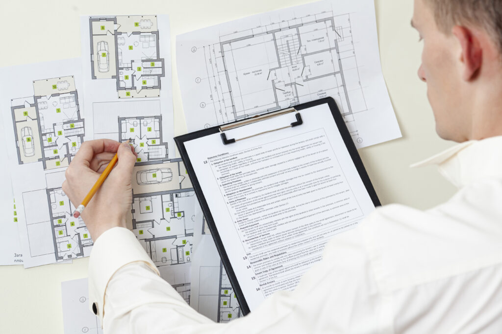 Reviewing apartment plans and documentation during a pre-settlement inspection.