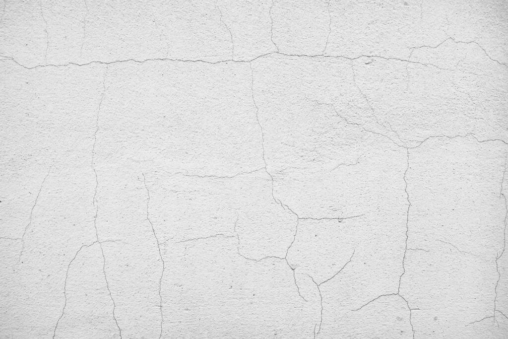 Network of fine cracks spreading across a white rendered wall on a Melbourne townhouse